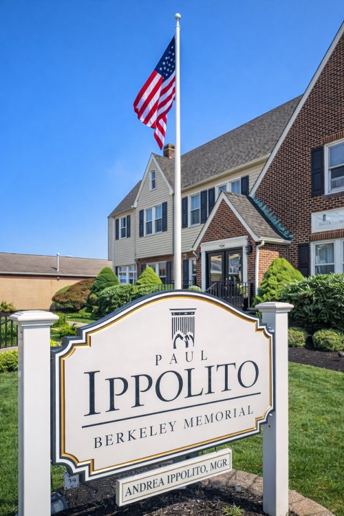 Exterior of Paul Ippolito Berkeley Memorial with U.S. flag and signage, representing trusted Berkeley, NJ funeral home and cremations.